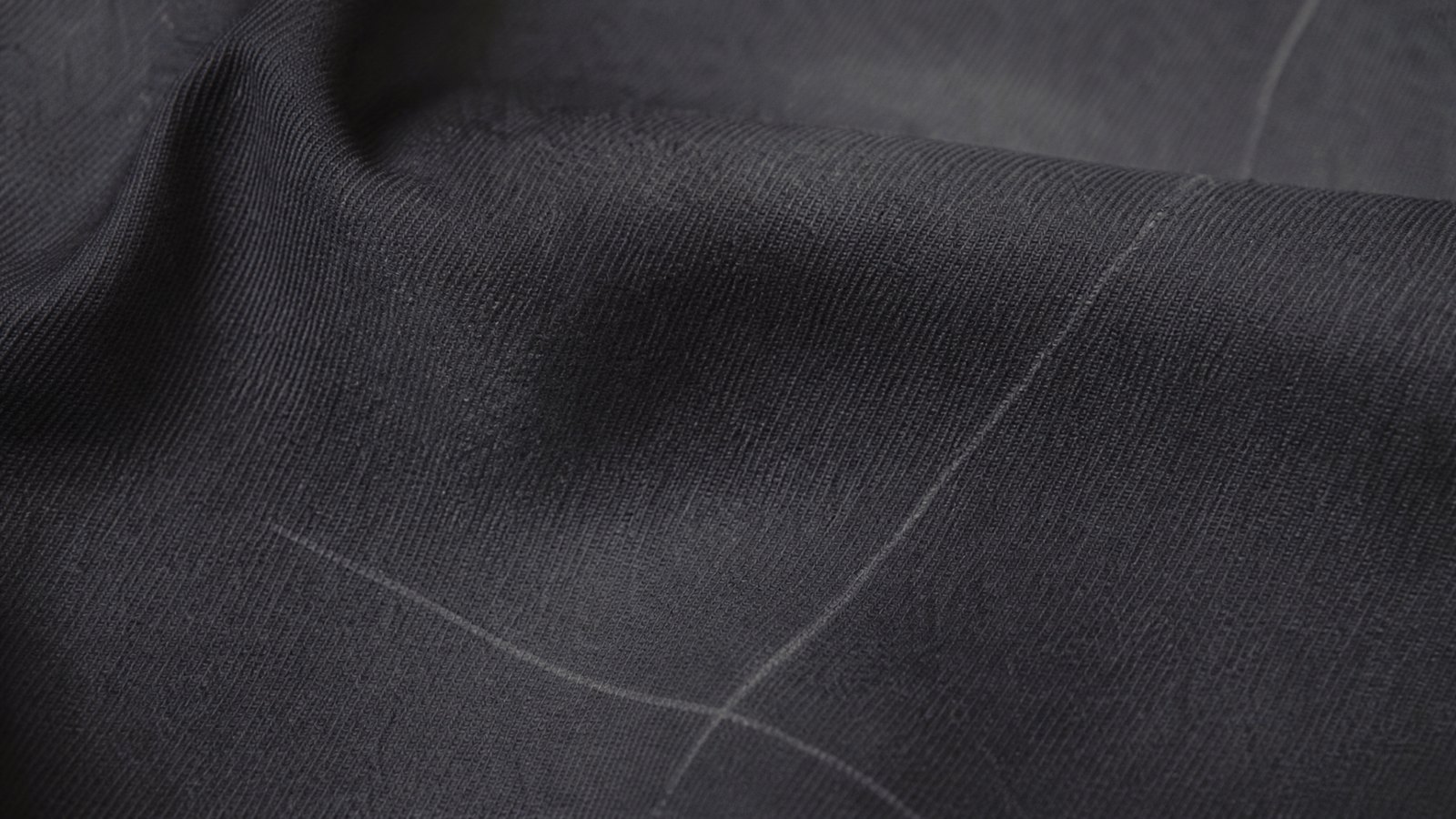 Close detail of overlapping charcoal ribbed and oatmeal cable knitted fabric