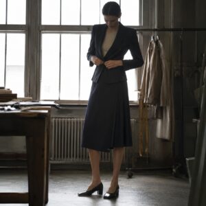 Marylebone box-pleated wrap skirt — Tailored Skirts by CROWN TAILORING. worn by a model.